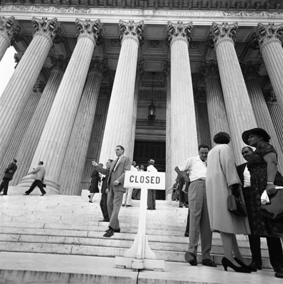 In this Aug. 28, 1958 black-and-white file photo, people walk by the closed front entrance of the Supreme Court in Washington. 